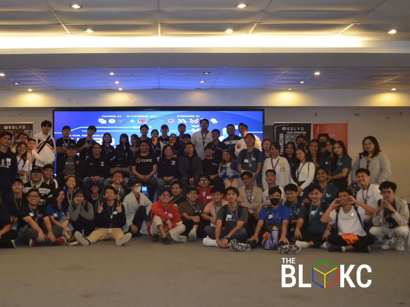 A packed hall of students at a The BLOKC campus event, with partner and sponsor logos shown on the stage screen.