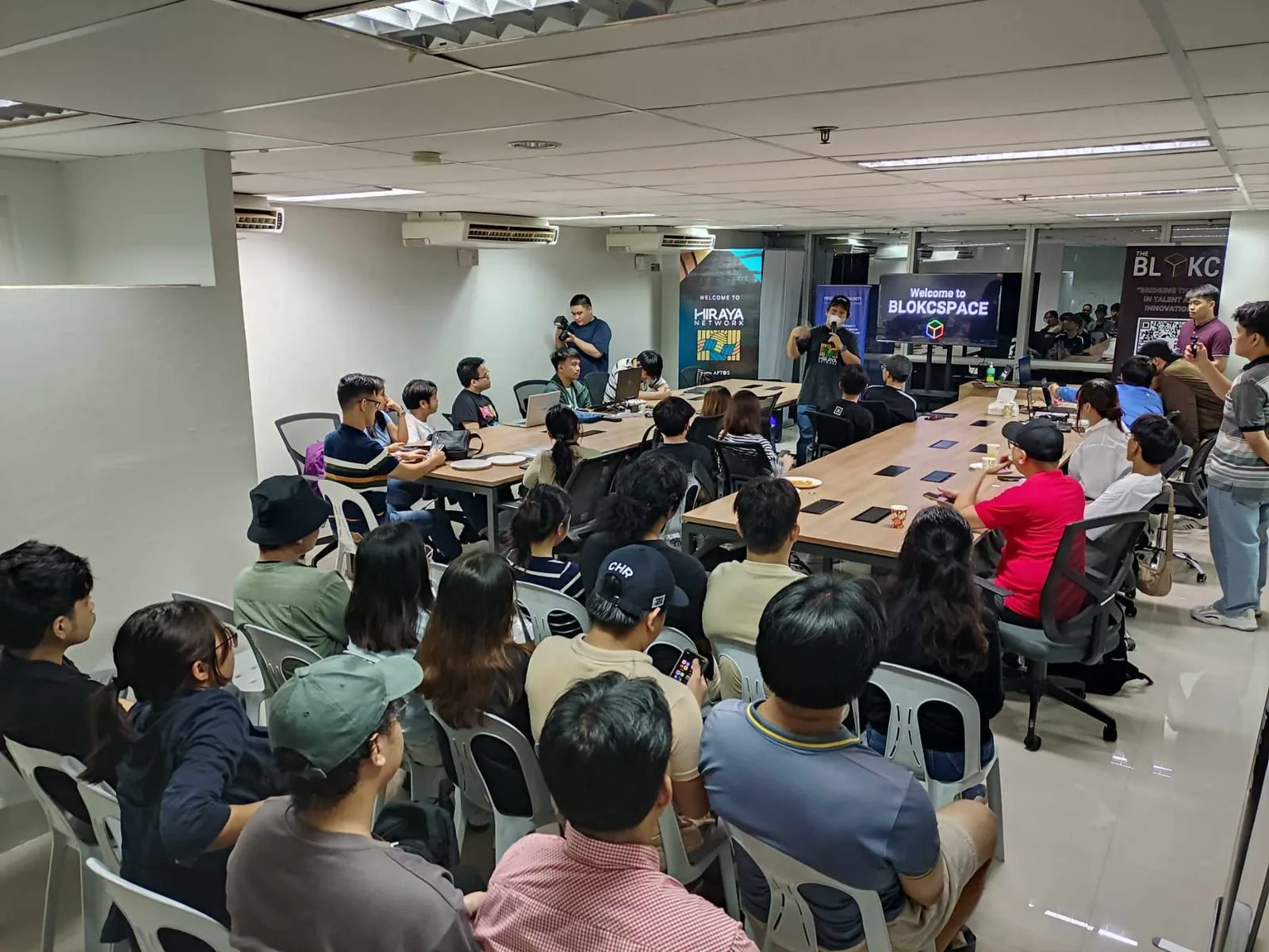 A full room of builders at The BLOKC's BLOKCSPACE innovation hub watching a project demo.