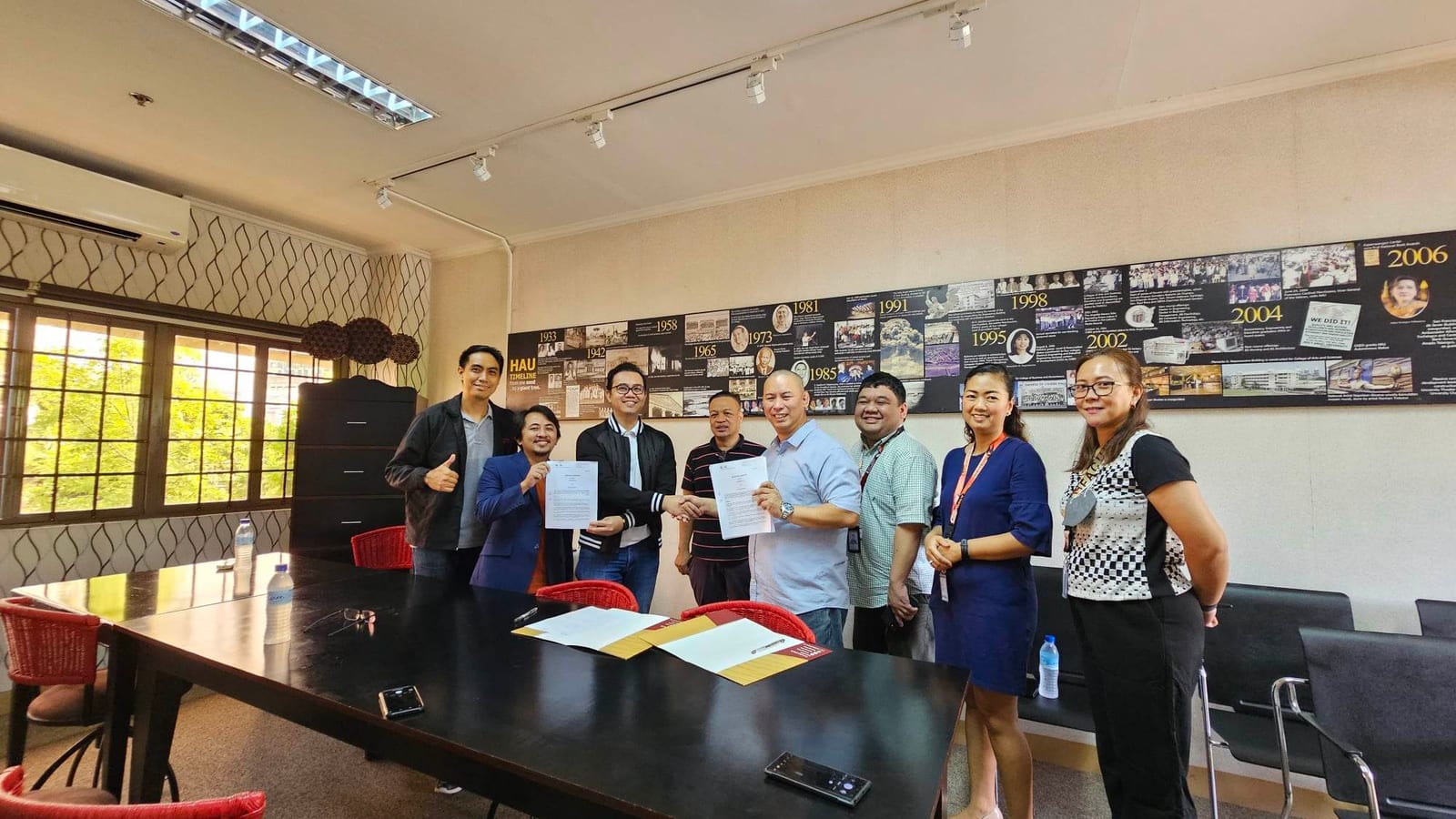 The BLOKC and Holy Angel University representatives exchanging signed partnership documents.