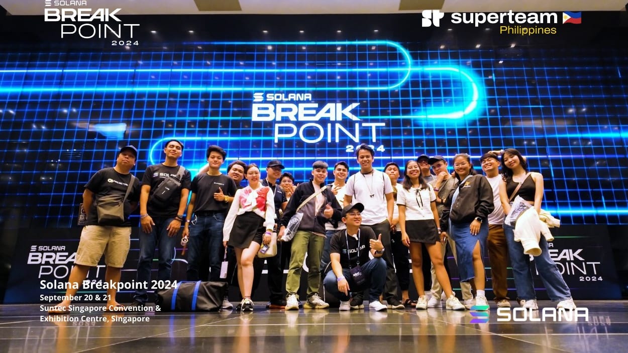The Superteam Philippines delegation posing in front of the Solana Breakpoint 2024 stage at the SunTec Convention Centre in Singapore.