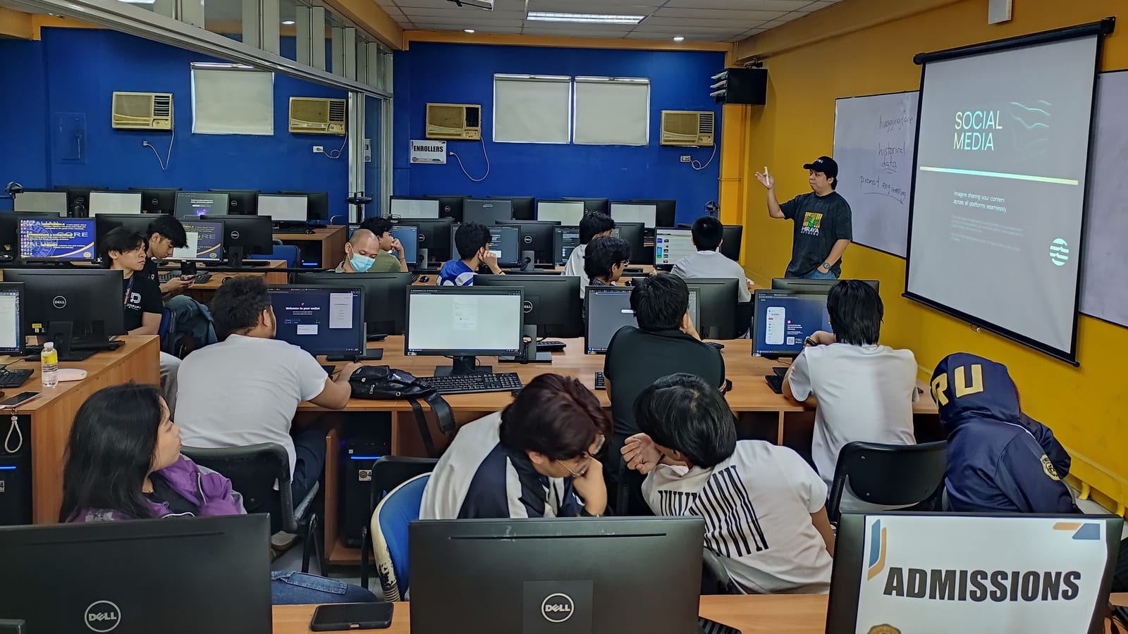 A BLOKC instructor presents a "Take It to the Next Level" blockchain slide to a packed auditorium of Institute of Information and Computer Sciences students.