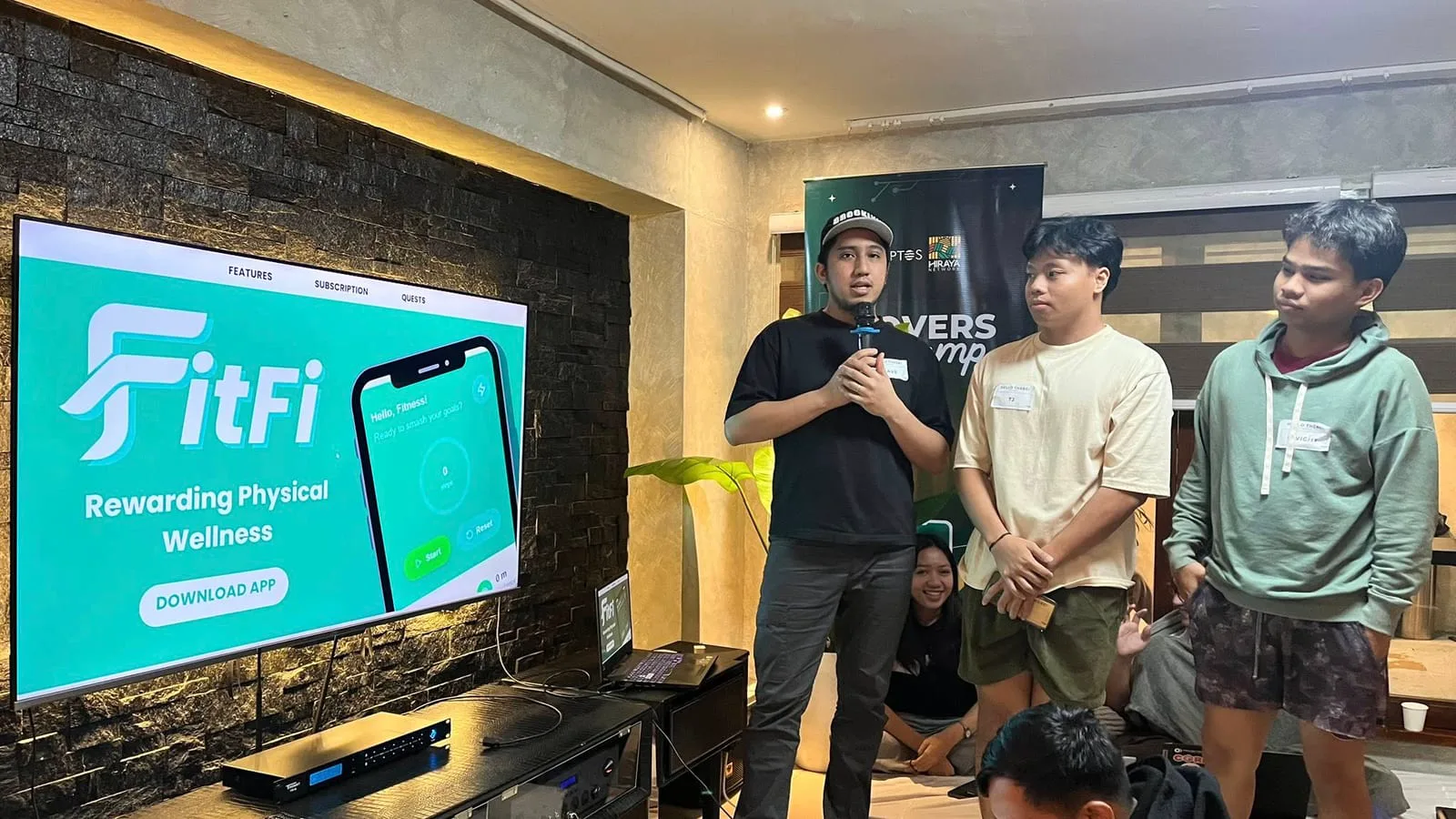 A builder demos the FitFi physical-wellness rewards app to fellow campers.