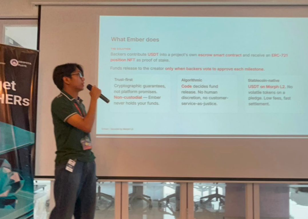 An intern pitches the Ember escrow project on stage during a hackathon demo day.